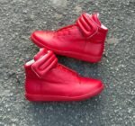 These Maison Margiela Future high top sneakers feature a vibrant red finish with a signature thick padded ankle strap and a sleek structured silhouette. The bold color and distinctive ankle detailing create a striking and contemporary appearance.